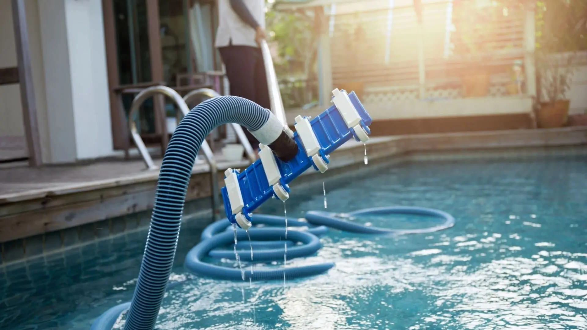 Vacuum being used to clean in ground plaster pool.